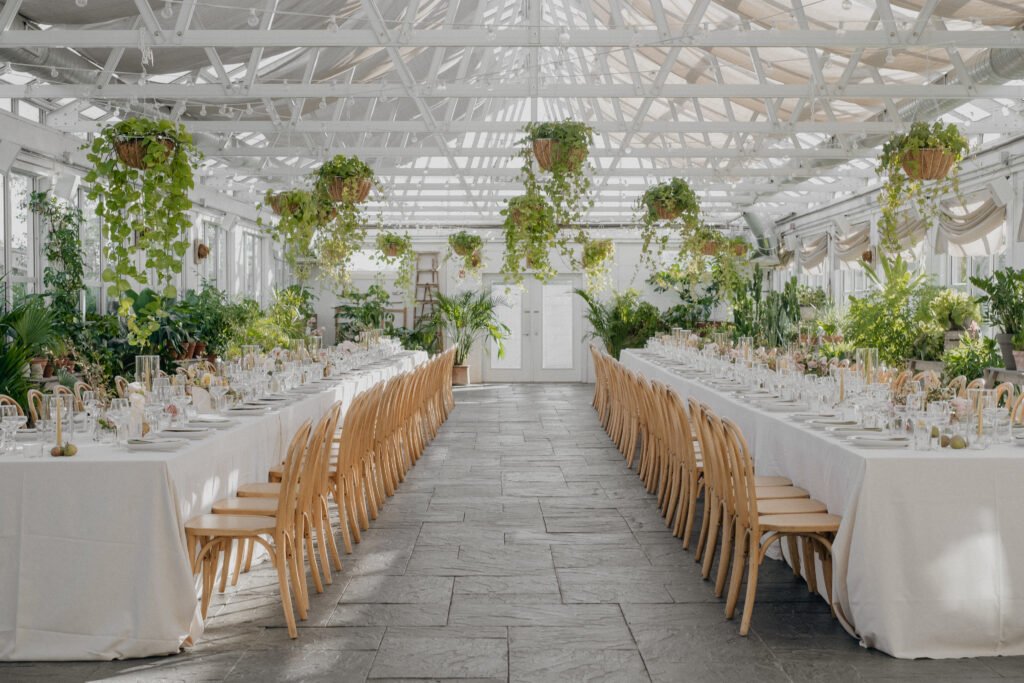 October wedding at Audrey's Farmhouse long tables with neutral linens in a greenhouse