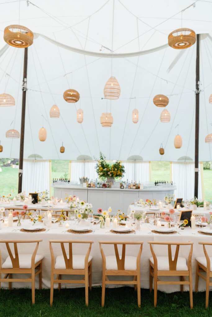Rattan lights hanging in sailcloth tent with lightf florals